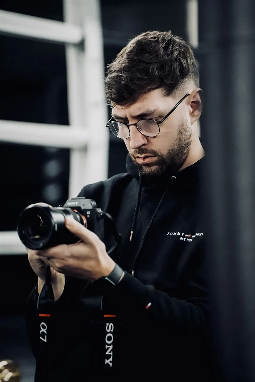 Portrait de Hugo Fernandez, photographe sportif BRASKO, appareil photo en main